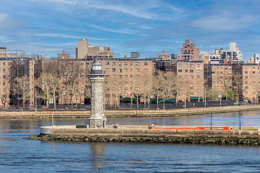 Blackwell Island Lighthouse, also known as Welfare Island Lighthouse or Roosevelt Island Lighthouse, once stood as a guiding beacon along the East River in New York City. It was located on what is now known as Roosevelt Island. The lighthouse was constructed in 1872, and its purpose was to aid vessels navigating the treacherous waters of the East River, especially around Hell Gate, a challenging tidal strait.\n\nThe lighthouse was relocated to the northern end of Roosevelt Island in Lighthouse Park, about even with E 86th Street in Manhattan across the river. While the structure no longer functions as an active navigational aid, it stands as a historic reminder of New York City's maritime past and is accessible for visitors to explore and appreciate its legacy.