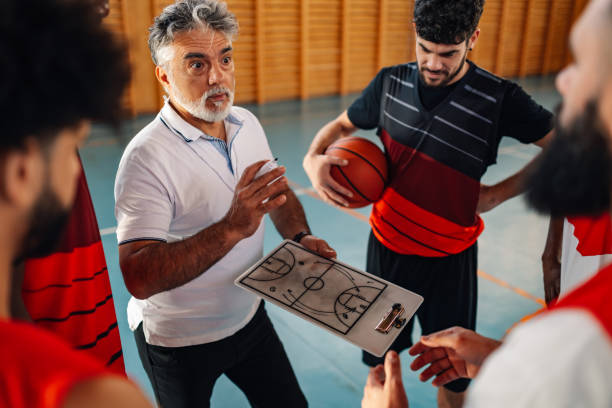 istock A senior coach working on game plan with his basketball team. 2041100504