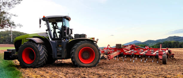 tractor with harrow, soil cultivation system in operation, plowed to prepare the soil for planting a new crop of agricultural crops