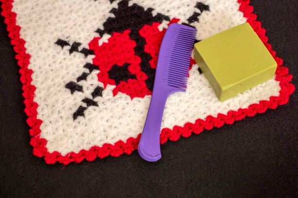 Beautifully patterned hand-knitted bath washcloth and comb soap stand side by side.