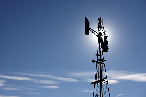 A Golden Weather Vane with an arrow against a clear blue sky