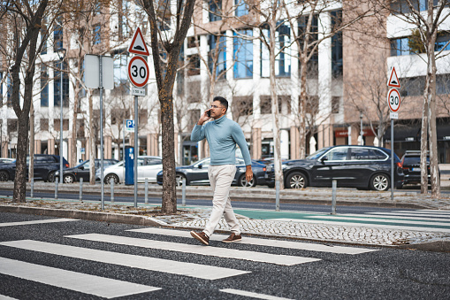 Businessman crossing the pedestrian crossing in Lisbon, Portugal
