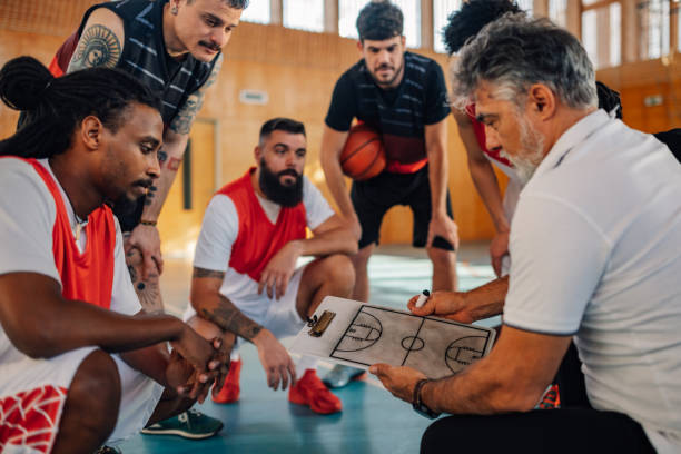 istock Interracial basketball team working on game plan with his coach on training. 2041197285