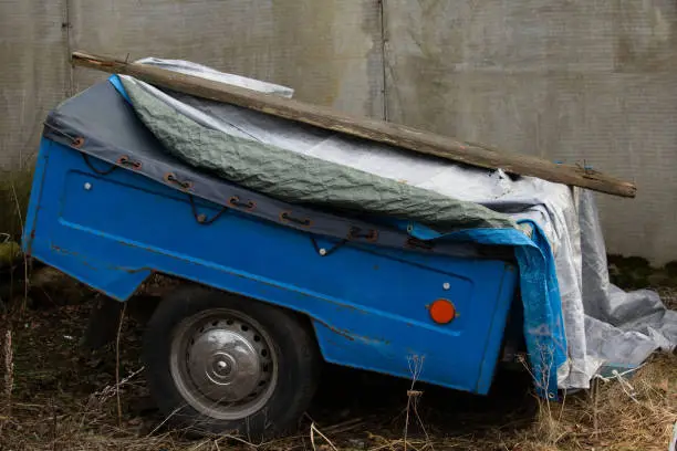 Photo of abandoned car trailer in a backyard