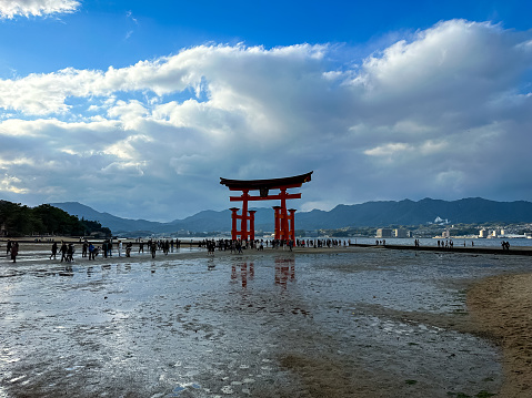 Miyajima, Itsukushima island, Japan - 12.11.2023. Tourists visiting the Itsukushima Shrine Torii Gate in Miyajima island in Hiroshima prefecture in Japan.