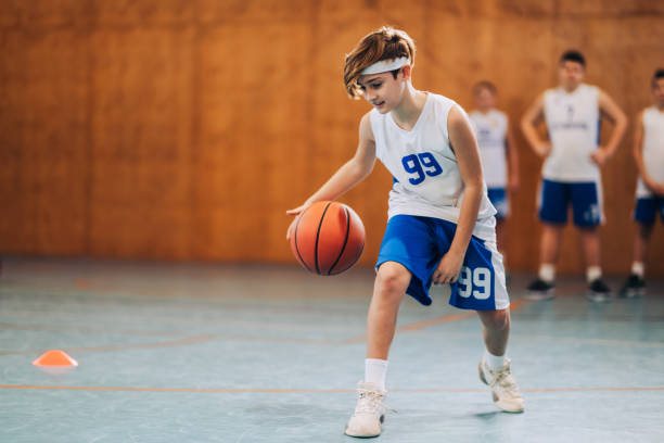 istock A junior basketball player is dribbling a ball and learning moves. 2041276545