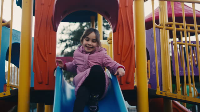Slow motion dramatic video of children having fun and playing in the playground