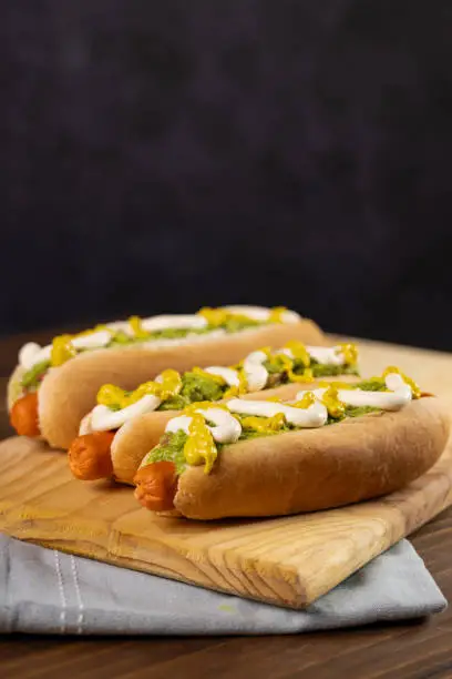 Photo of Chilean Typical Completo Food Hot dog with tomato, avocado palta and mayonnaise Selective Focus.