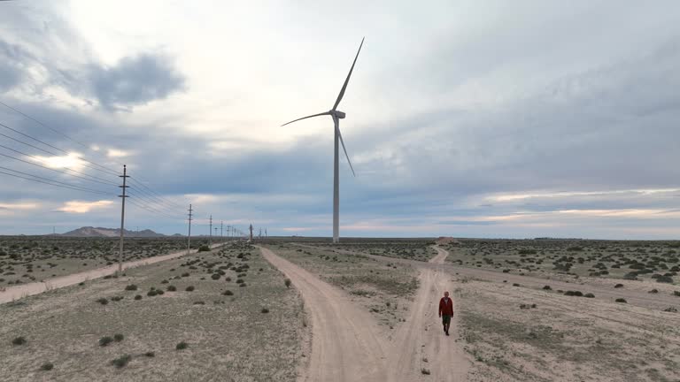 Aerial view of man walking near wind turbine