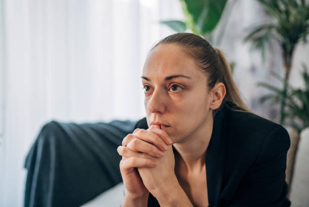 A person clasps their hands during a therapy session
