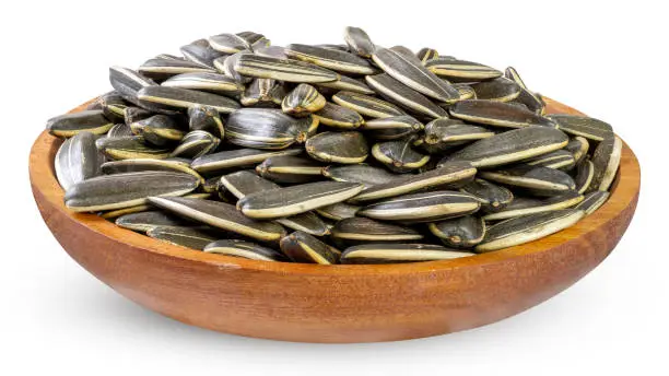 Dried sunflower seeds in a wooden bowl isolated on white background