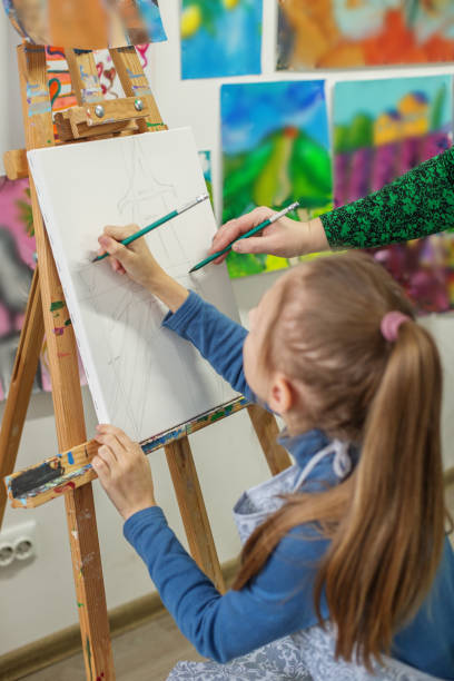 istock Child Drawing on Canvas in a Colorful Art Class 2041456804