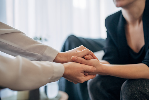 A therapist and patient are captured in a moment of connection, their hands joined in mutual support. The scene epitomizes empathy, understanding, and the silent strength that defines the therapeutic relationship.