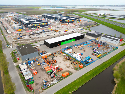 Aerial view of a distribution warehouse with trucks and trailers in rows at loading docks.