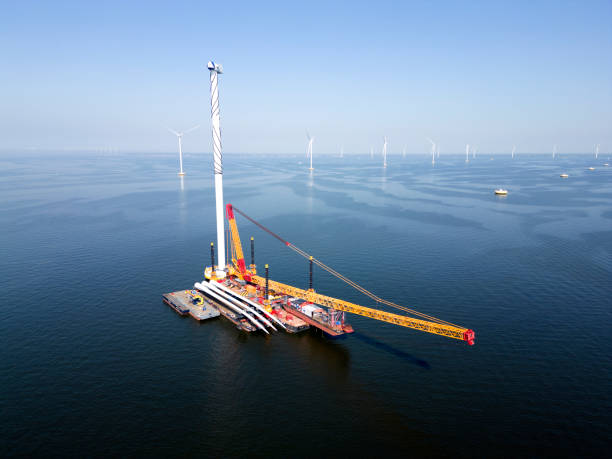 A transport ship and crane for constructing an offshore windpark A transport ship and crane for the construction of an offshore windpark, Ijsselmeer The Netherlands offshore wind farm stock pictures, royalty-free photos & images