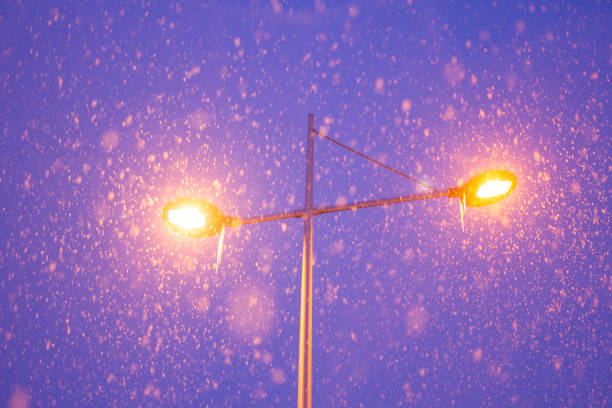 Lamppost with two orange lamps at night.