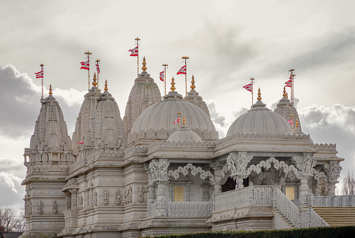 London, UK - Feb 23, 2024 - The exterior architectural design of the Neasden temple (BAPS Shri Swaminarayan Mandir) with sky background. Hindu temple in Neasden to build is constructed from Italian Marble, hand carved in India, Copy space, Selective focus.