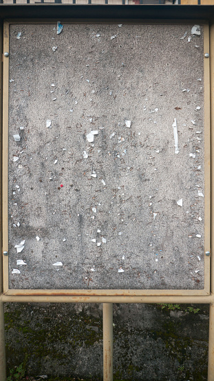 Pins and staples in weathered cork board