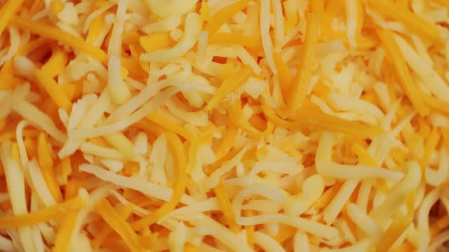 Some different sorts of grate cheese on plate close up macro. Chef grating cheese mozzarella, cheddar for meals. Itallian food, pizza, pasta.