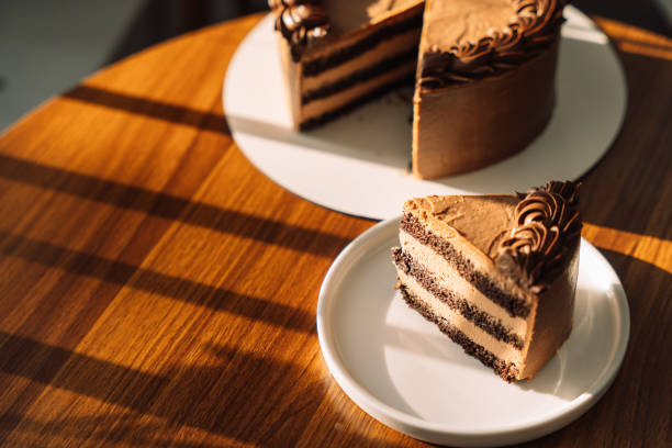 istock Cut puff chocolate piece from a cake on a white plate on a wooden table 2041611819