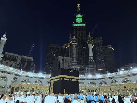 Jeddah, 28 October 2023 : Muslim pilgrims at the Kaaba in the Grand Mosque of Mecca, Saudi Arabia, In the evening performing Umrah, Hajj. Zamzam tower. many people. wallpaper, poster, background