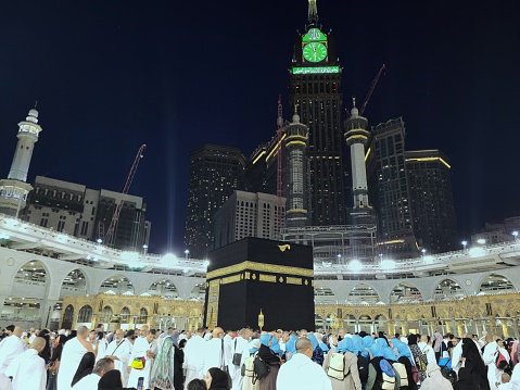 Jeddah, 28 October 2023 : Muslim pilgrims at the Kaaba in the Grand Mosque of Mecca, Saudi Arabia, In the evening performing Umrah, Hajj. Zamzam tower. many people. wallpaper, poster, background