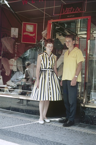 Berlin (West), Germany, 1959. Two young adults wait for a textile store to open.