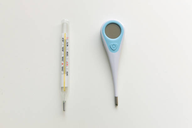 Horizontal photo of one woman with thumb down pointing a contactless or non contact Infrared Thermometer isolated over white background with copy space for text. The action is like shooting a gun.
