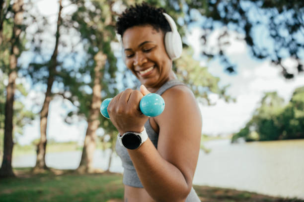 istock Woman doing physical exercise with dumbbells in the park 2041737305