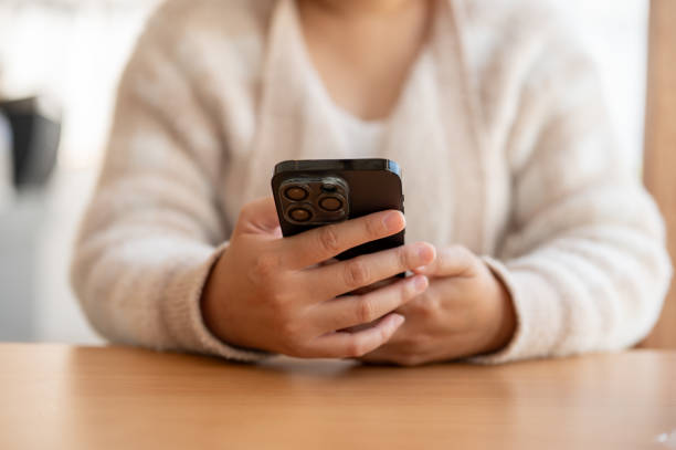 istock A woman using her smartphone, chatting or reading messages, while sitting at a table in a cafe. 2041750698
