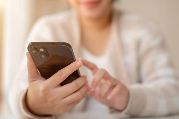 istock A woman using her smartphone while sitting at a table by the window in a coffee shop. 2041753262