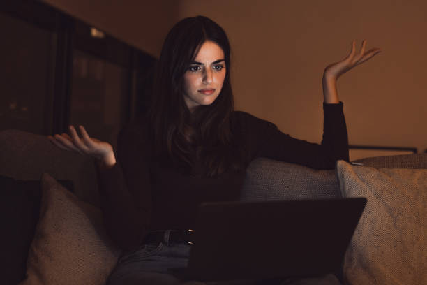 Unhappy young female worker look at laptop screen shocked by gadget breakdown or operational problems at late night. Frustrated woman confused surprised by unexpected error on computer device.