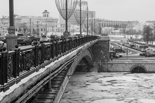 Climate change leads to global natural disasters, abnormal temperatures, heavy snowfalls, typhoons and droughts. View of Borovitskaya Square from the bridge over the winter Moscow River during a snowfall. Black and white.