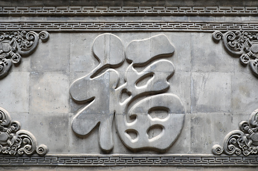 The word Fu is carved on a gray wall in North China