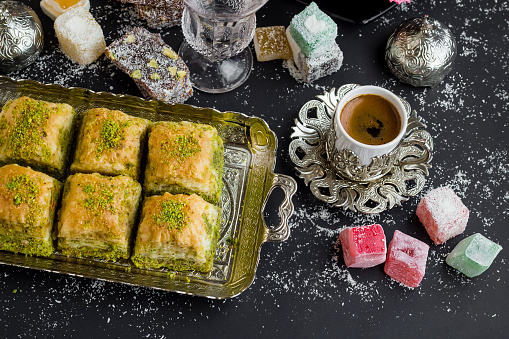 Top view of Traditional Turkish Pastry Pistachio Dry Baklava,on vintage tray with coffee and delights.Conceptual image of celebrations.
