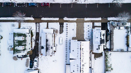 Snowy driveways and parked cars line Greenwood Ave in residential Madison, New Jersey. Top view