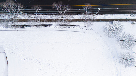 Snow footprints run along the road on a snow-covered stadium part in Madison, New Jersey