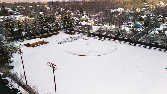 Madison, NJ stadium with basketball field features snow-covered residential area