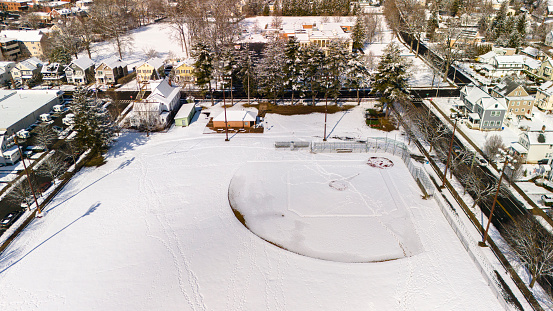 Snowy sports ground is surrounded by residential neighborhood in Madison, New Jersey