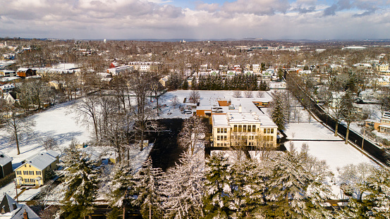 Snow covered area in Madison, New Jersey: white residential neighborhood, featured with houses and educational buildings