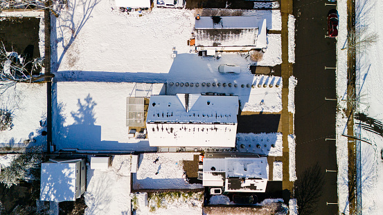 Residential houses with snow-covered rooftops in a small neighborhood in Madison, New Jersey. Directly above view