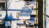 Sunny snowy rooftops line the road in residential area of Madison in New Jersey