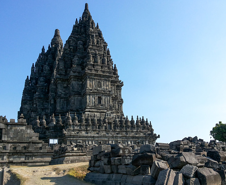 Low angle view of carvings on walls of Prambanan temple against blue sky