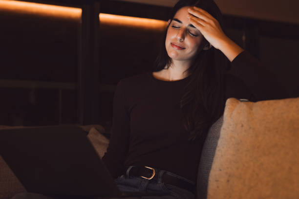 istock Stressed woman at late night having strong terrible headache attack after computer laptop study, sleepy exhausted girl suffering from chronic migraine massaging temples to relieve head ache tension 2041957735