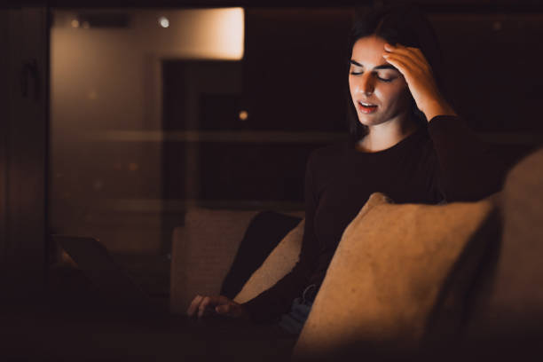 Stressed woman at late night having strong terrible headache attack after computer laptop study, sleepy exhausted girl suffering from chronic migraine massaging temples to relieve head ache tension