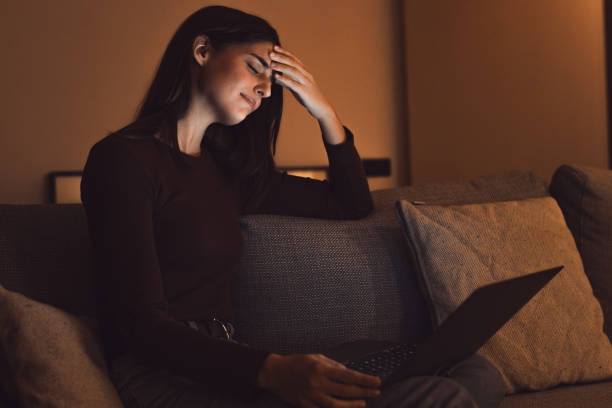 istock Stressed woman at late night having strong terrible headache attack after computer laptop study, sleepy exhausted girl suffering from chronic migraine massaging temples to relieve head ache tension 2041973758