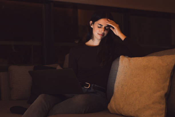 istock Stressed woman at late night having strong terrible headache attack after computer laptop study, sleepy exhausted girl suffering from chronic migraine massaging temples to relieve head ache tension 2041983523