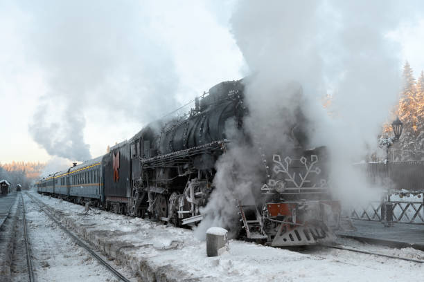 Ruskeala, Karelia, Russia - January 04, 2024.The locomotive has arrived at the railway station and is standing steam. View of a black retro train at Ruskeala station.