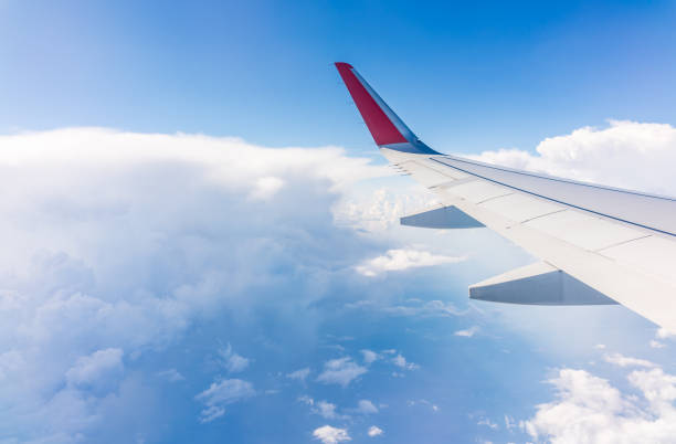 View from the airplane window at a beautiful cloudy sky and the airplane wing