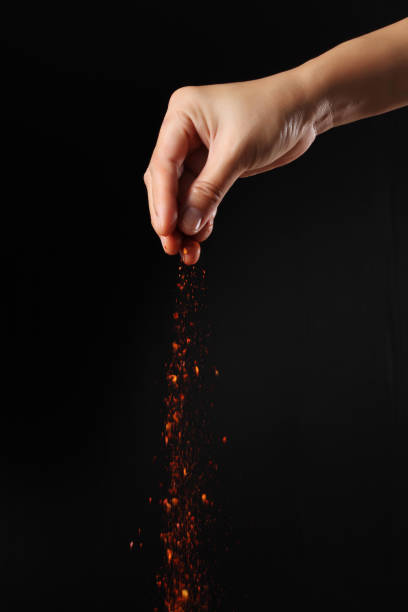 istock Hand holding cayenne pepper on black background 2042030196